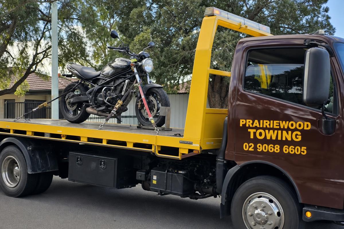 Motorbike strapped to a Prairiewood Towing tilt tray for motorbike towing